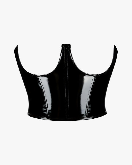 Corset cuir seins nus sur fond studio gris clair